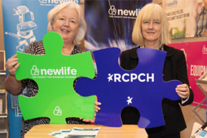 Staff from Newlife charity with children's disability partnership signs