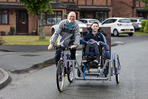 An older man on an Insync Bike and young boy on special needs trike design