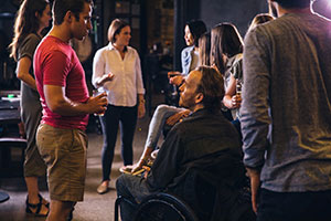 A group of people from an inclusive company - one with a disability - drinking and talking